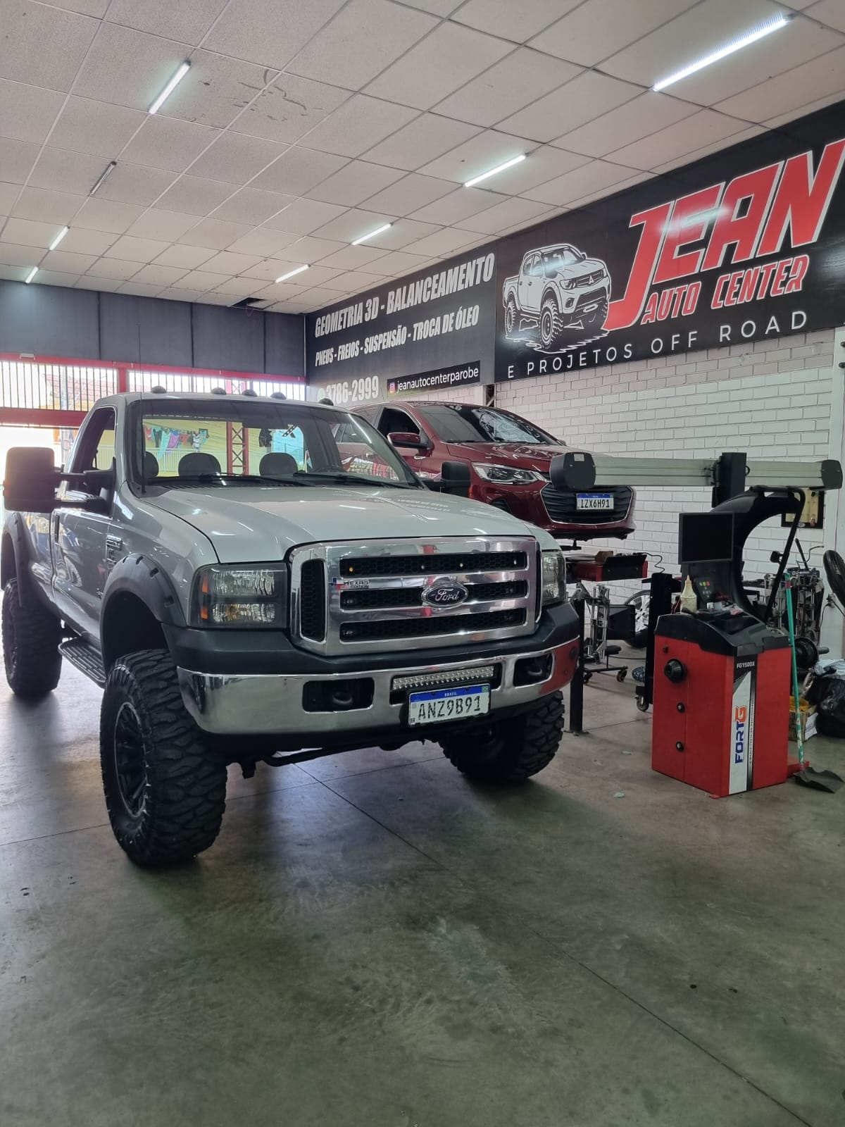 Ford F-250 branca com suspensão elevada e rodas aro 18 pretas na Jean Auto Center Parobé