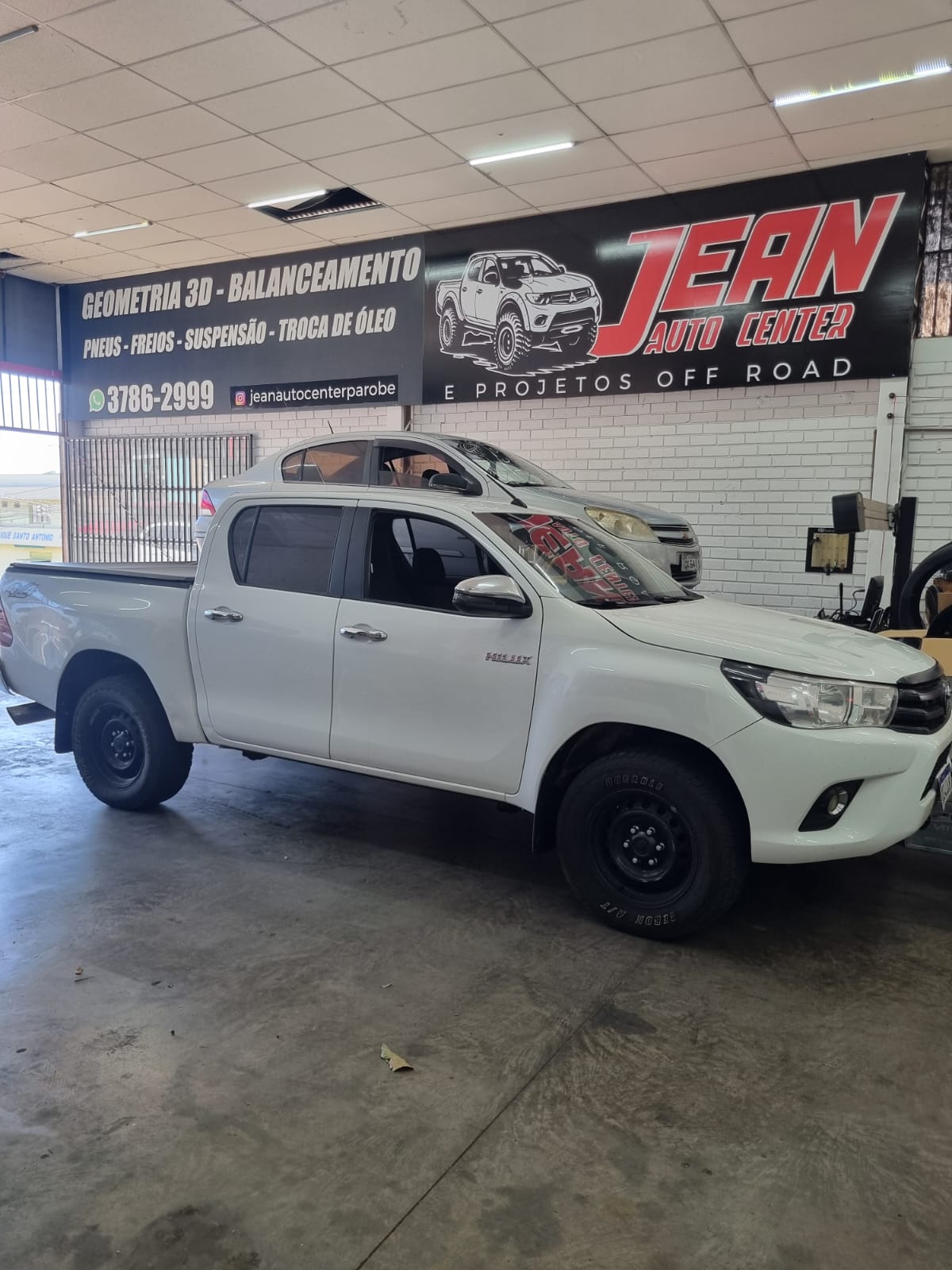 Toyota Hilux 4x4 branca preparada com rodas pretas na oficina Jean Auto Center