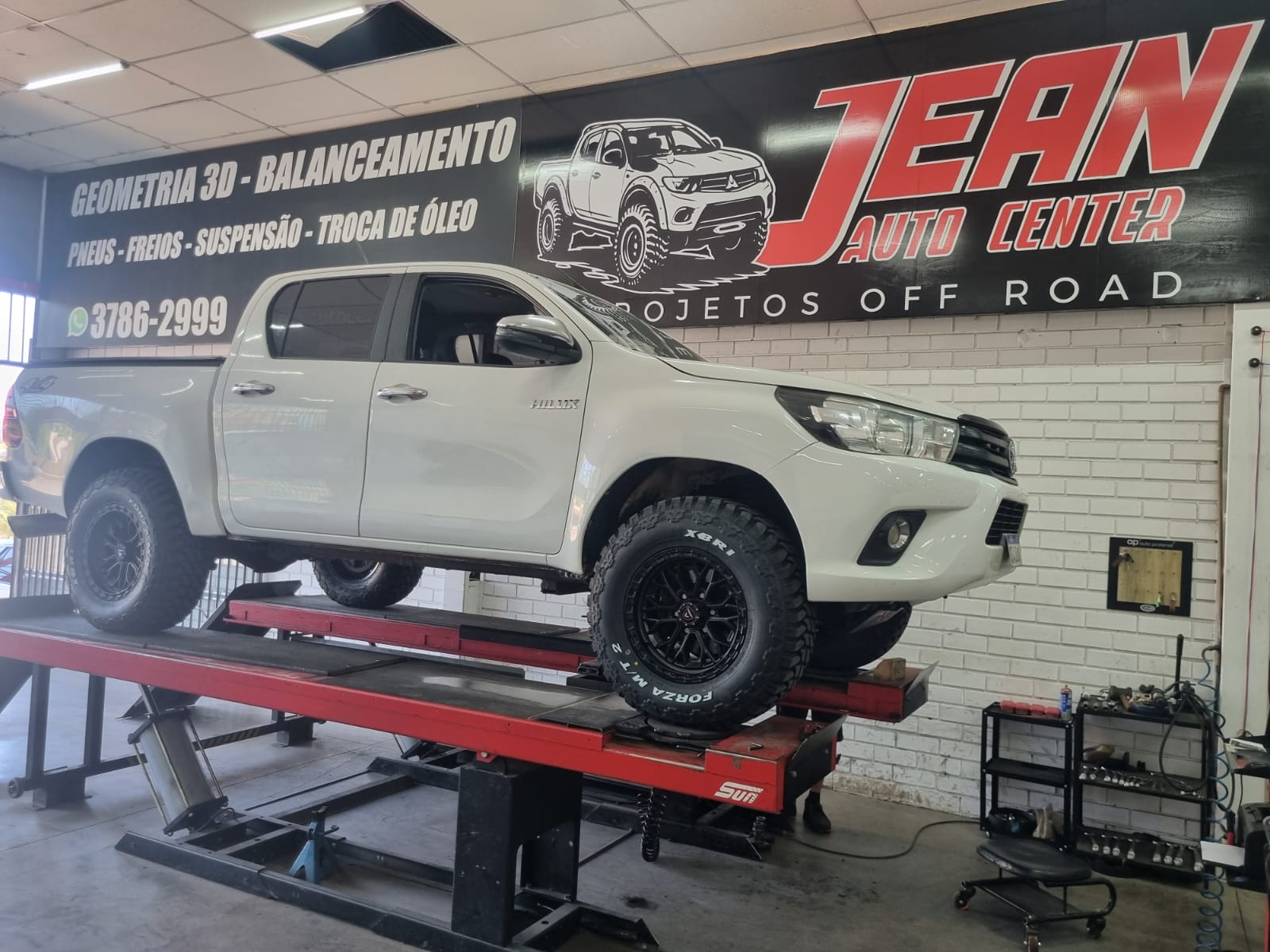 Toyota Hilux branca no alinhador de geometria 3D durante balanceamento