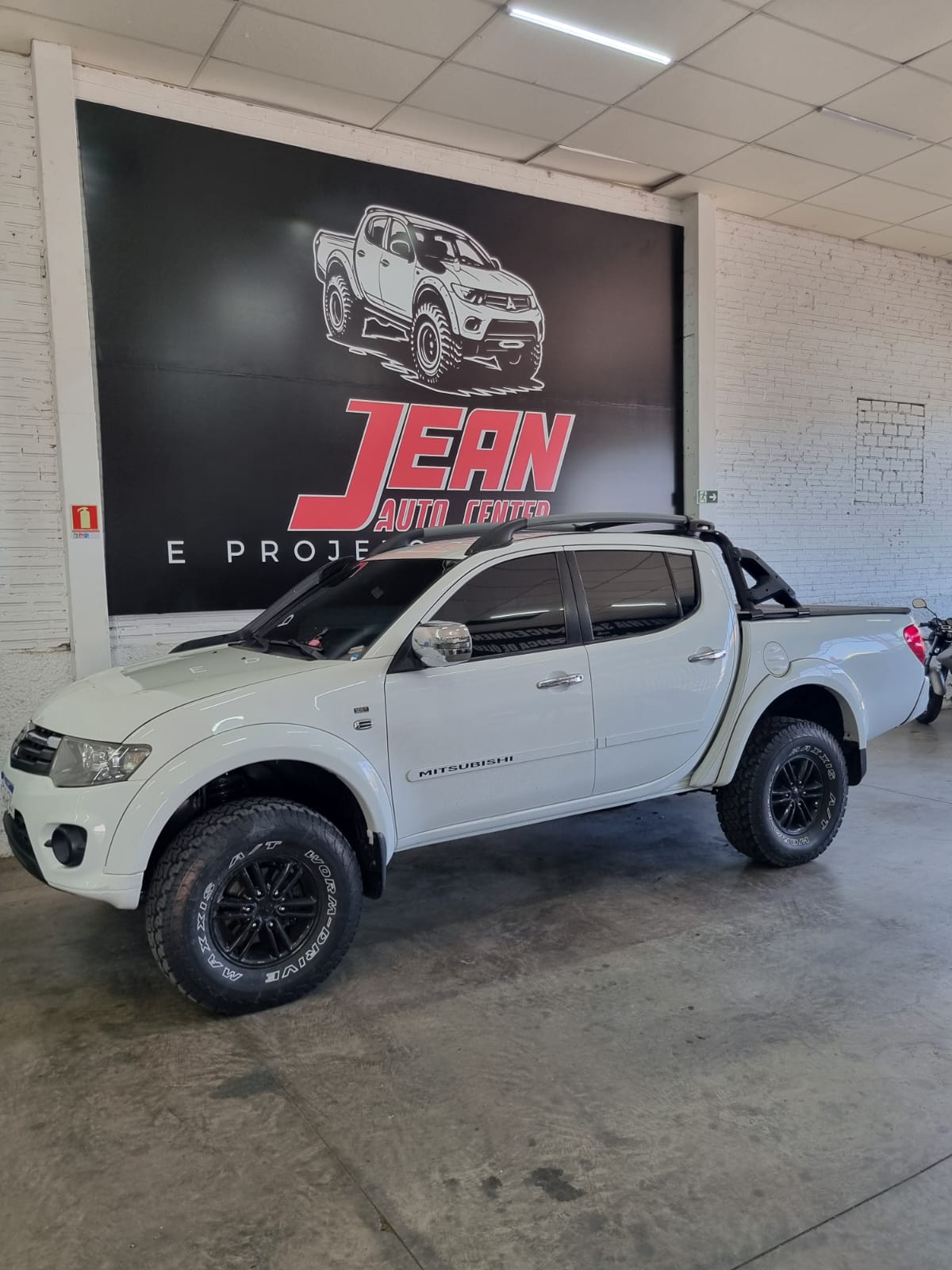Mitsubishi L200 Triton branca com snorkel e suspensão elevada, vista lateral
