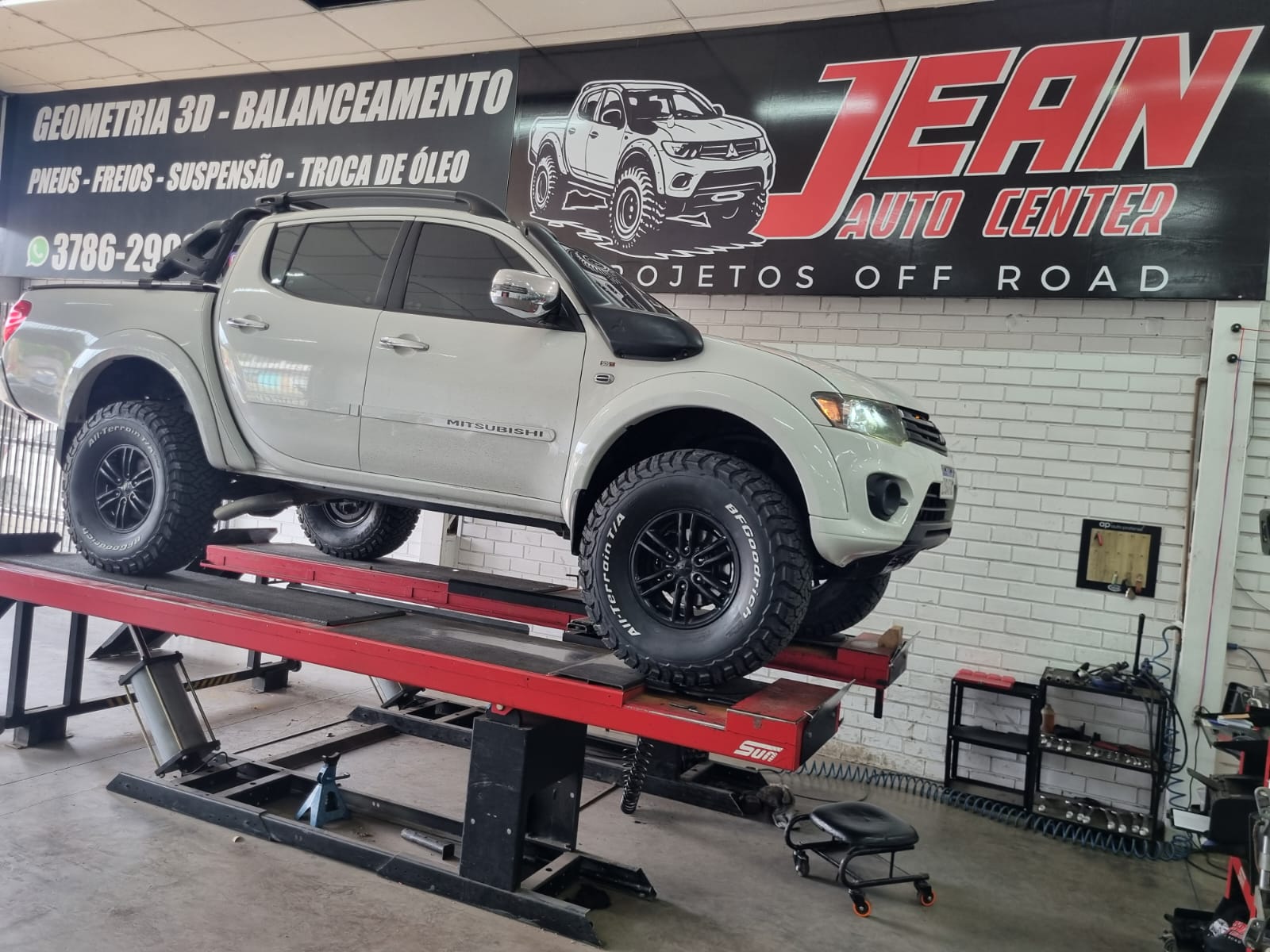 Mitsubishi L200 Triton branca elevada no alinhador de geometria 3D