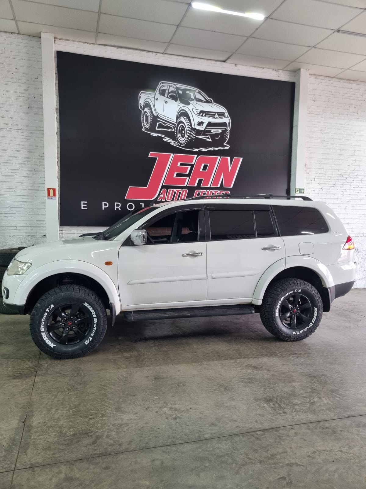 Mitsubishi Pajero Sport branco com suspensão elevada e rodas pretas